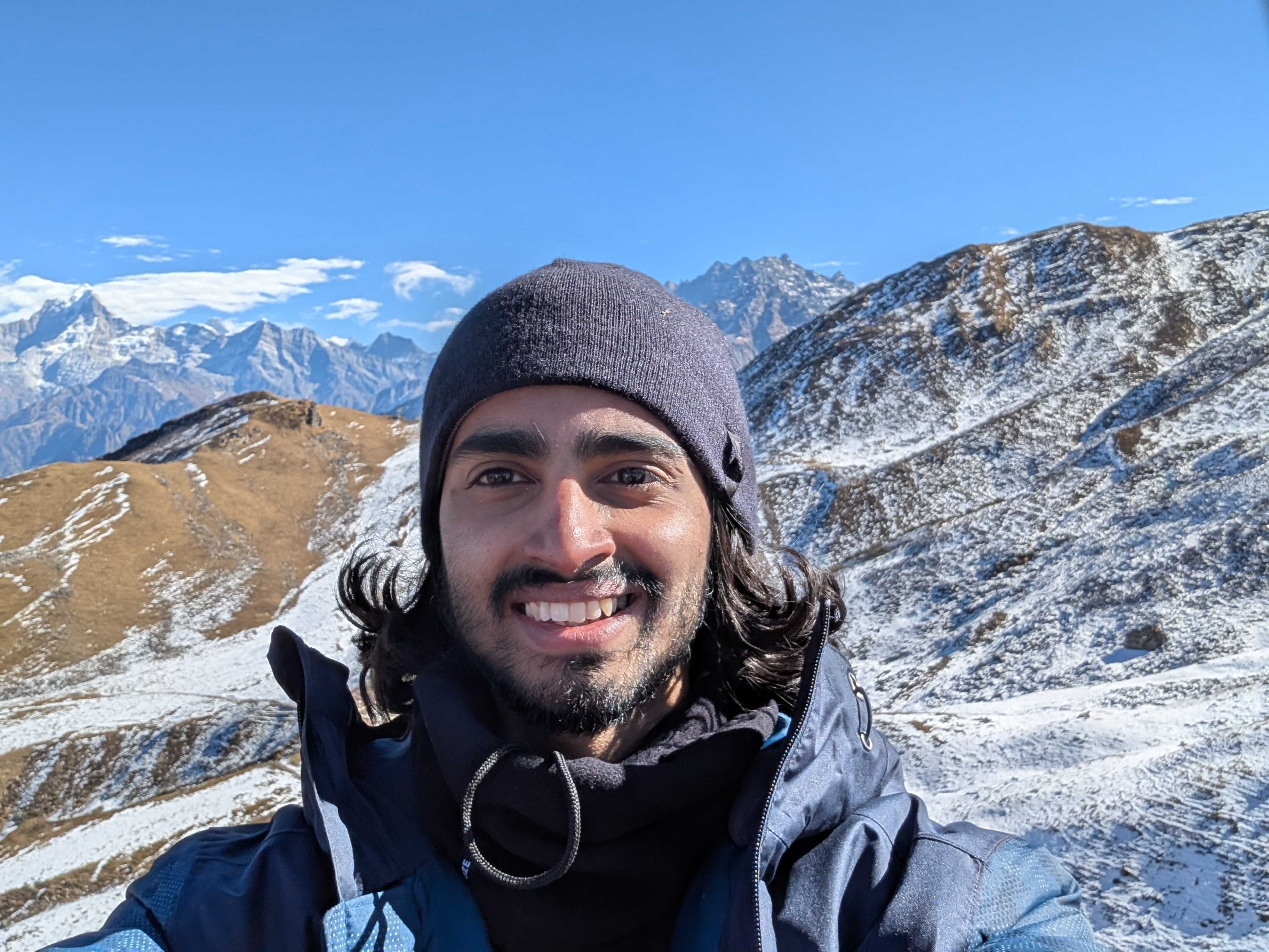 Adith smiling in a snowy mountain landscape